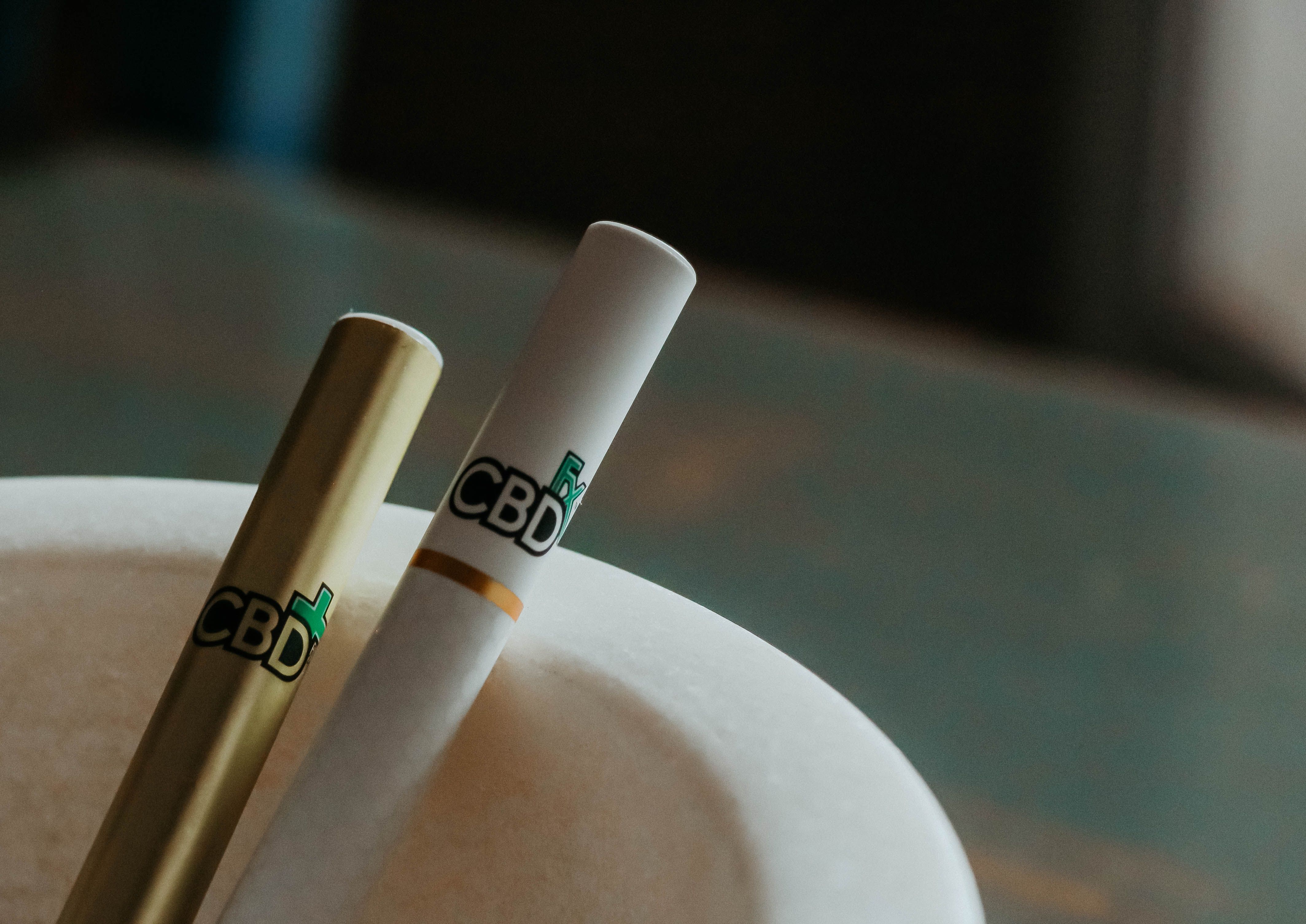 Close-up of CBD cannabis vape cartridges and pens resting in an ashtray