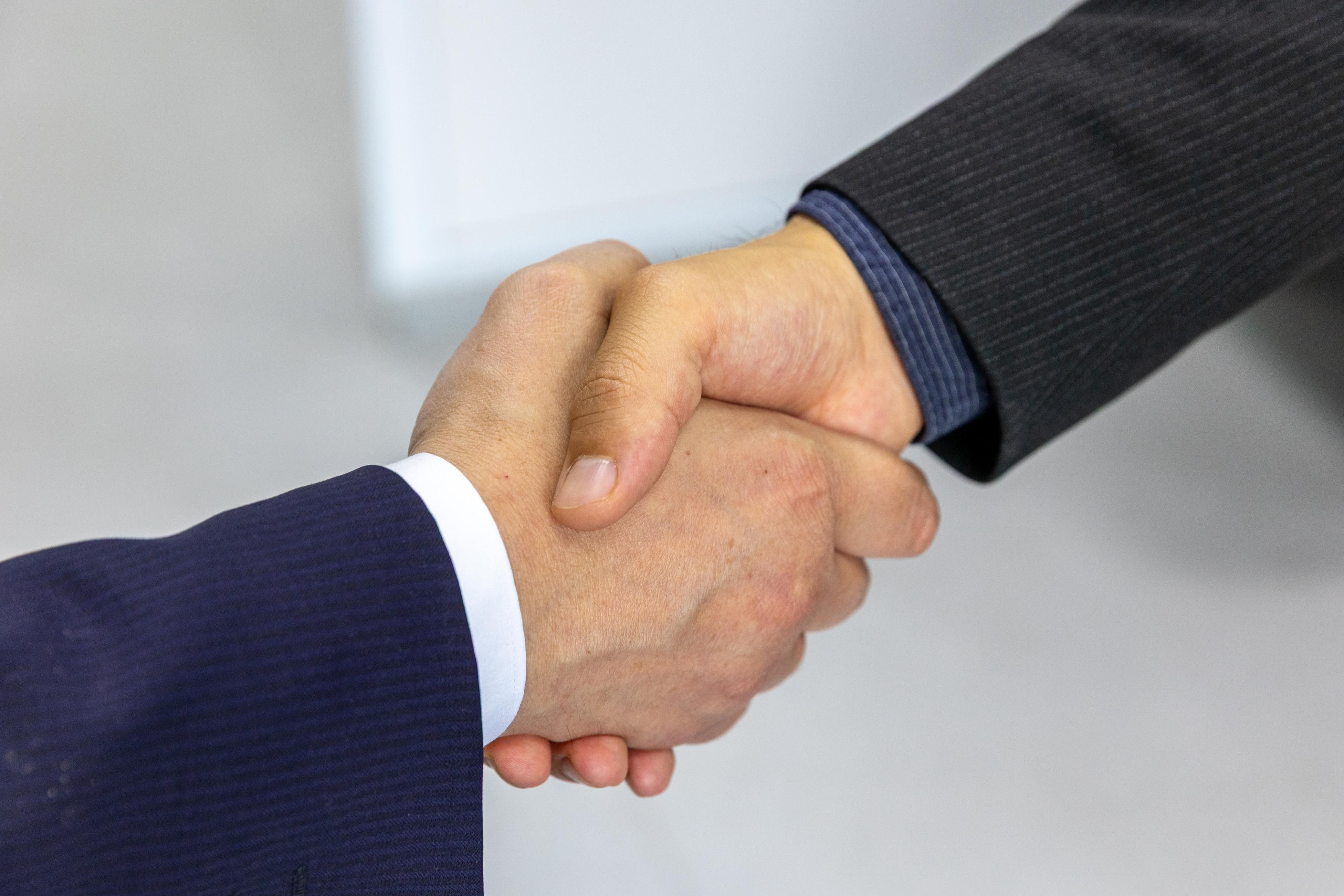 Close-up of two businessmen shaking hands, symbolizing a confident first impression