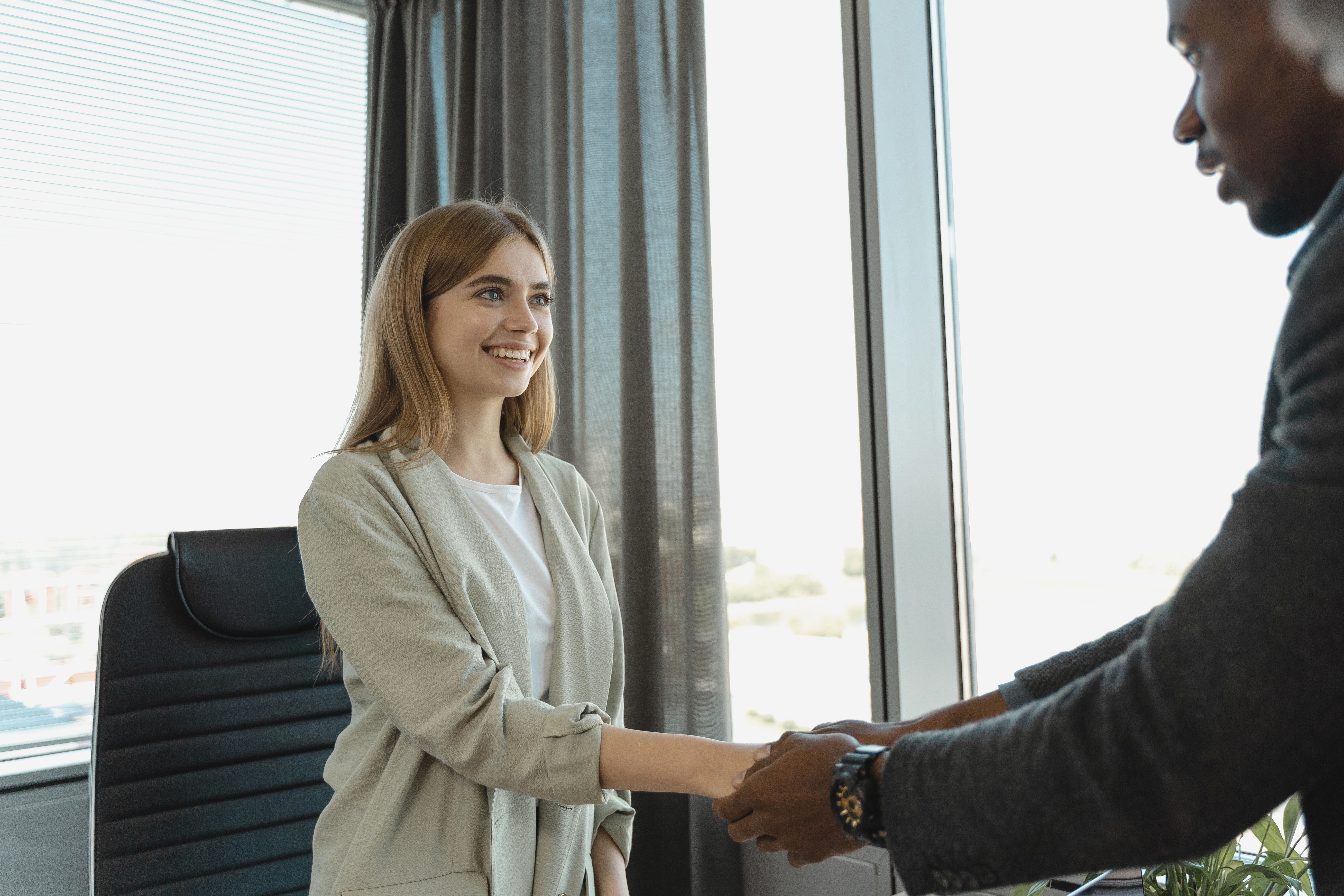 Woman smiling and shaking hands during a successful job interview