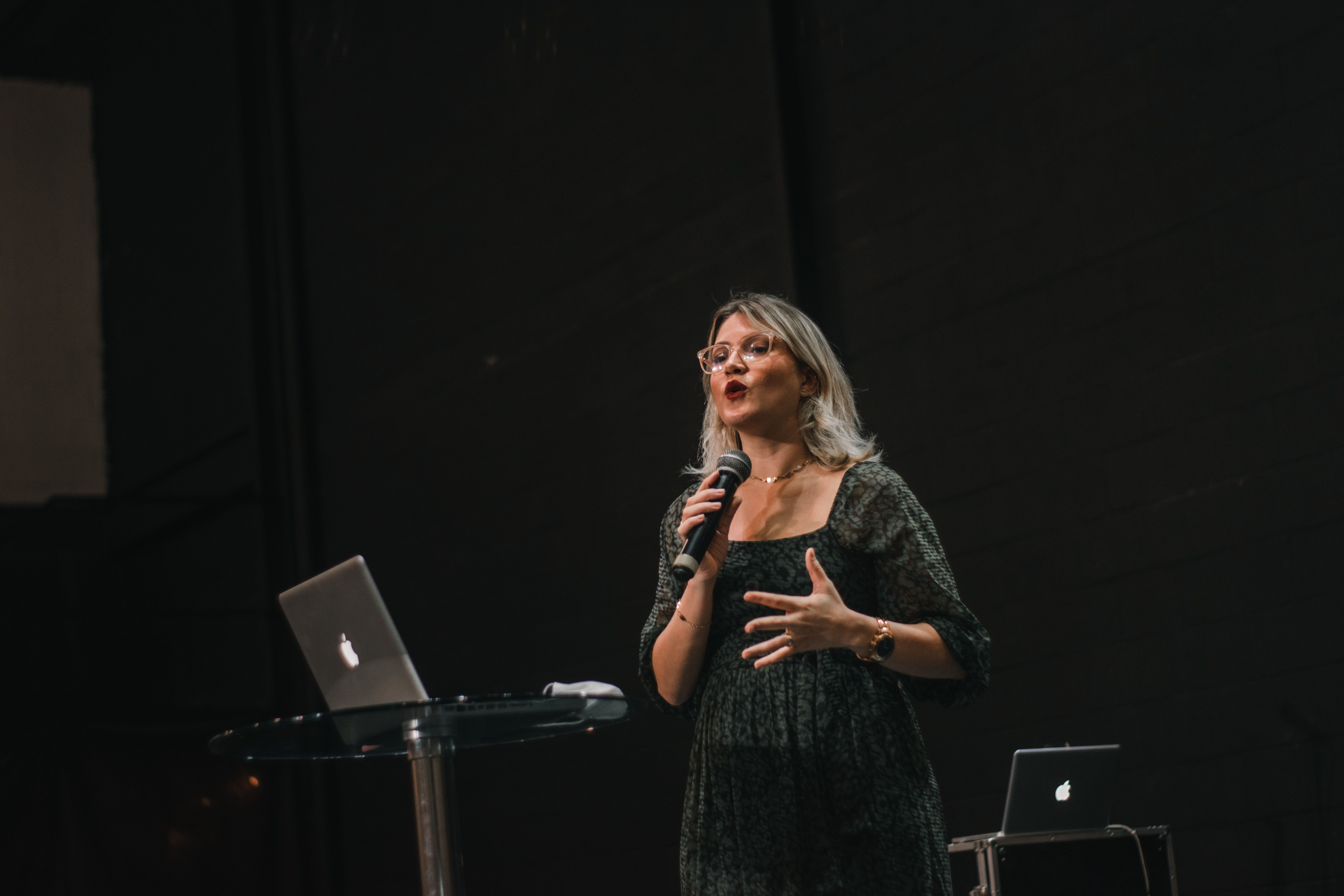 Confident woman delivering a speech on stage with a microphone