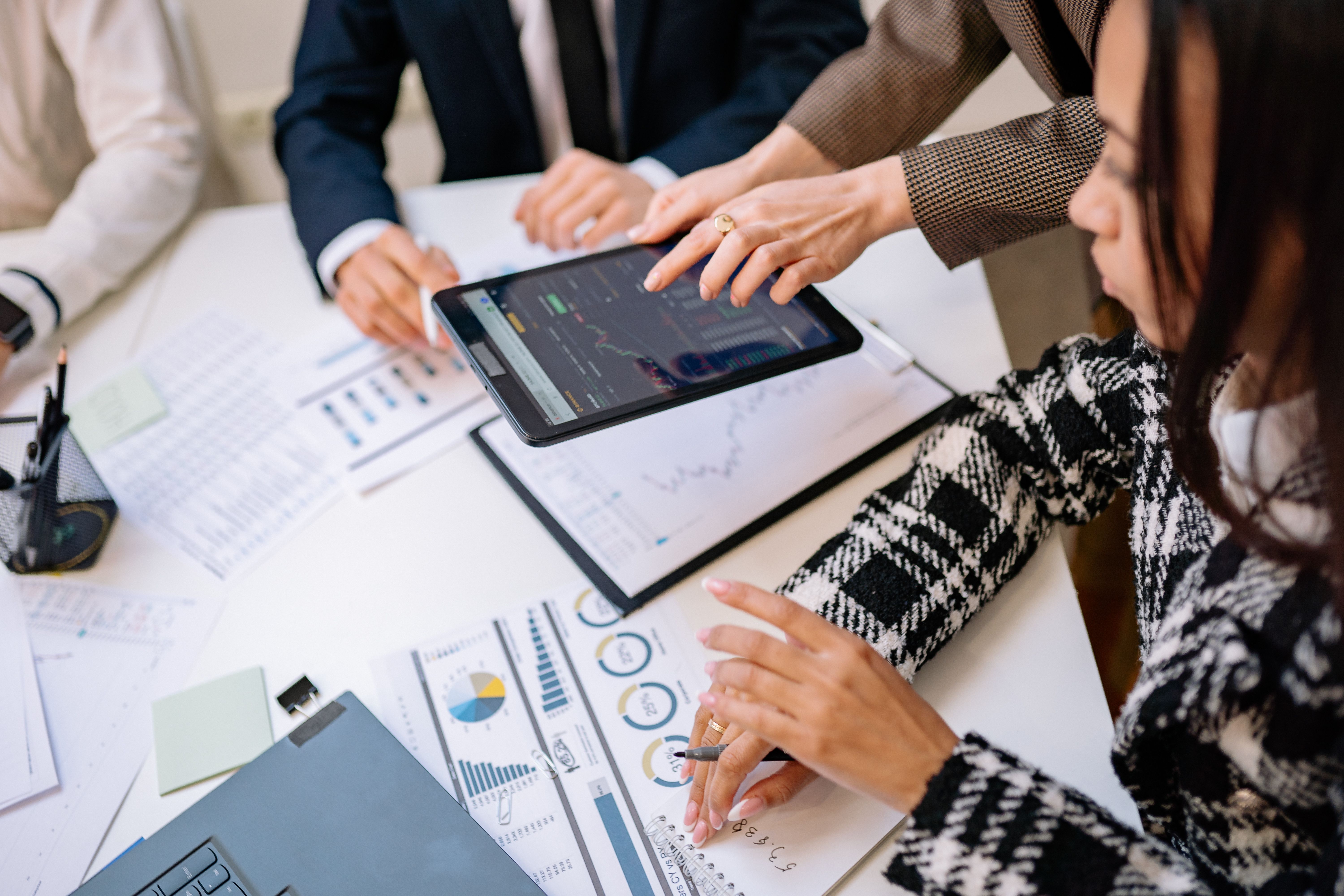 Business professionals reviewing marketing analytics on a tablet during a meeting